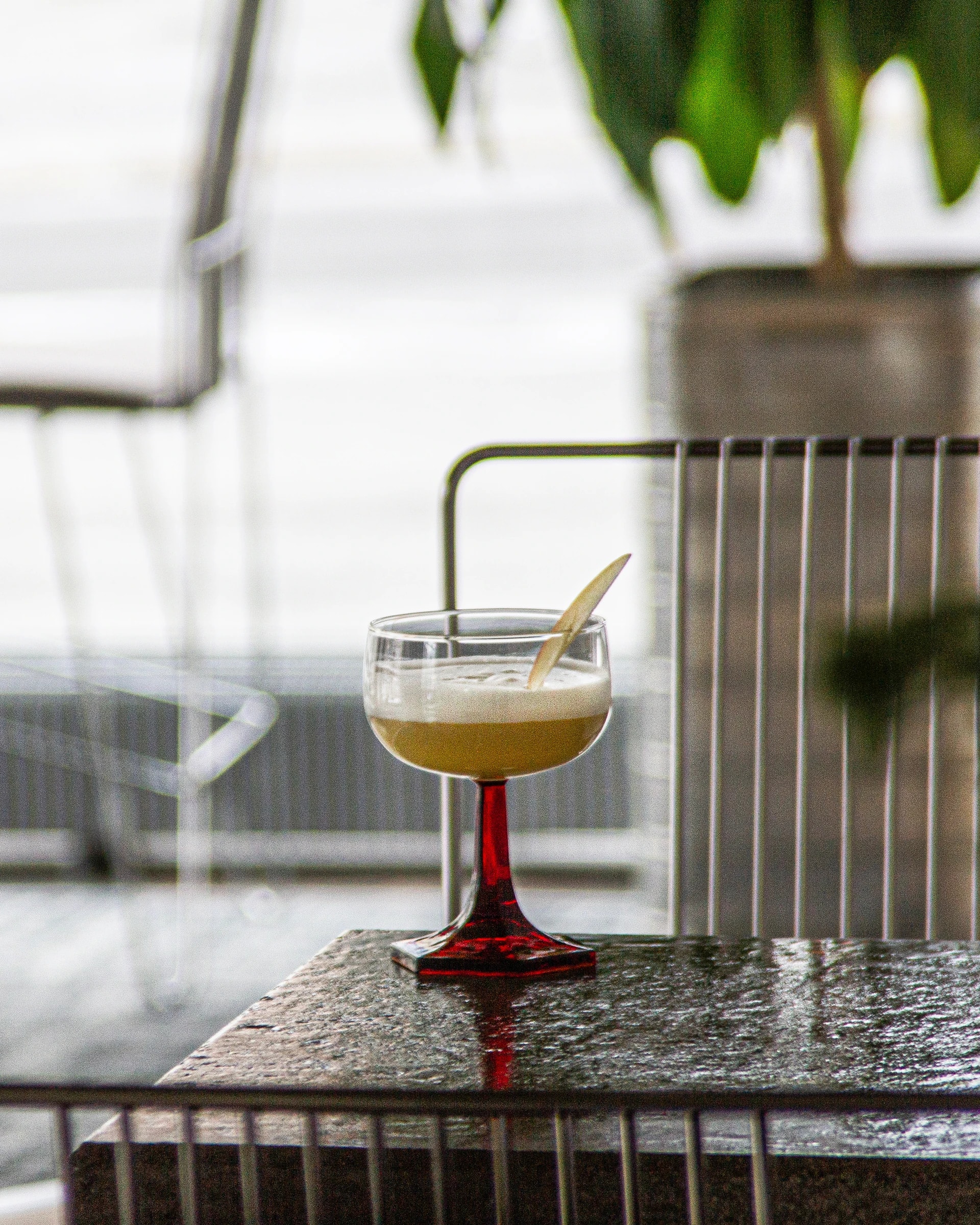 A golden drink in a red-stemmed glass on a table at Nöösi