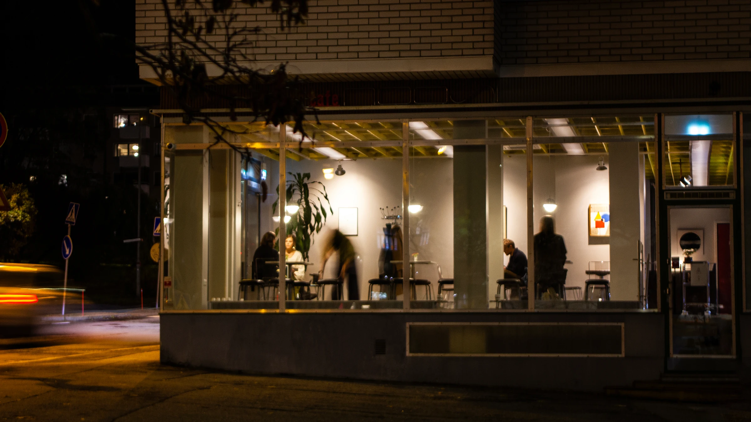 Cafe Nöösi's illuminated windows on Satakunnankatu in the evening